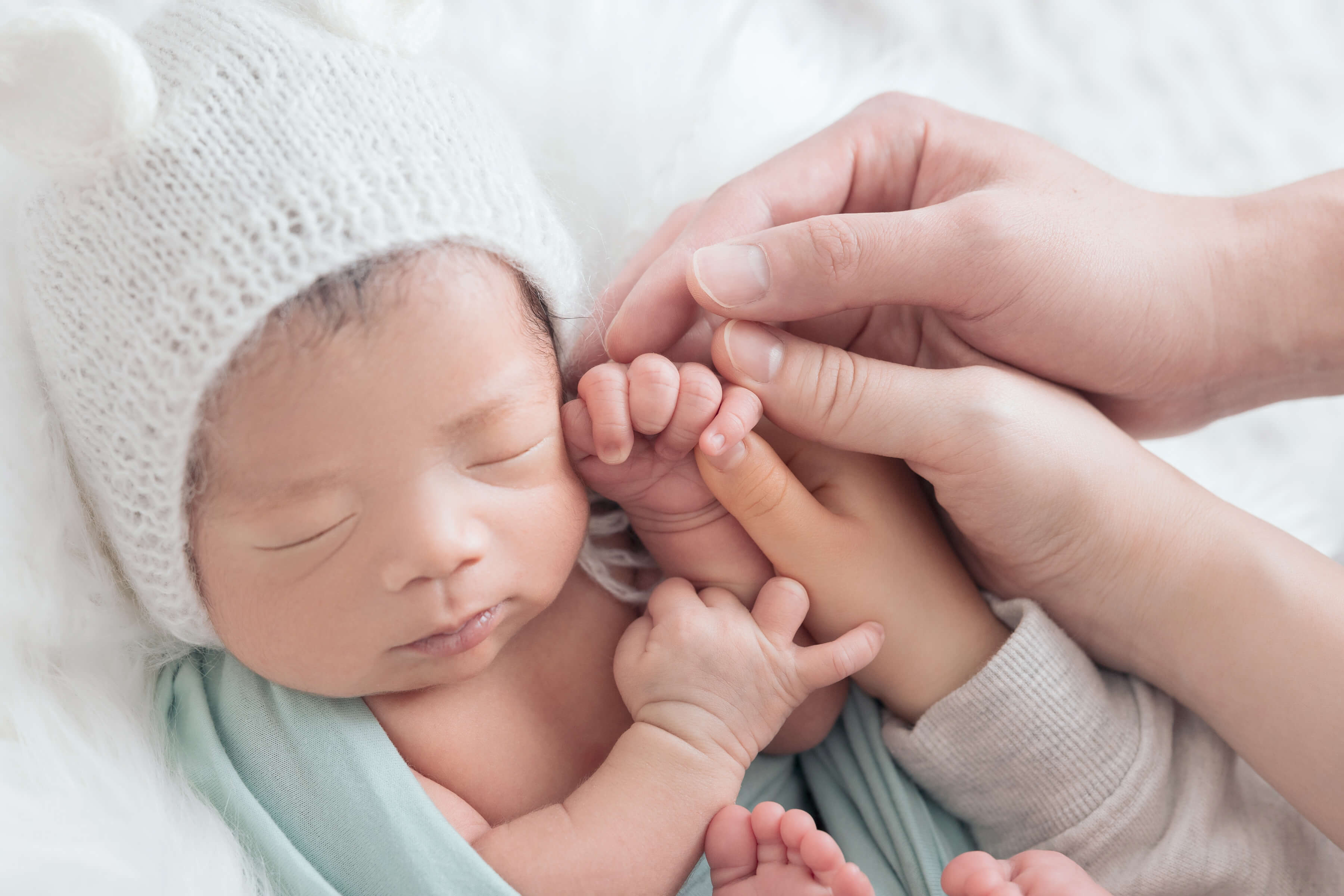 子供の手を家族でつないでる姿