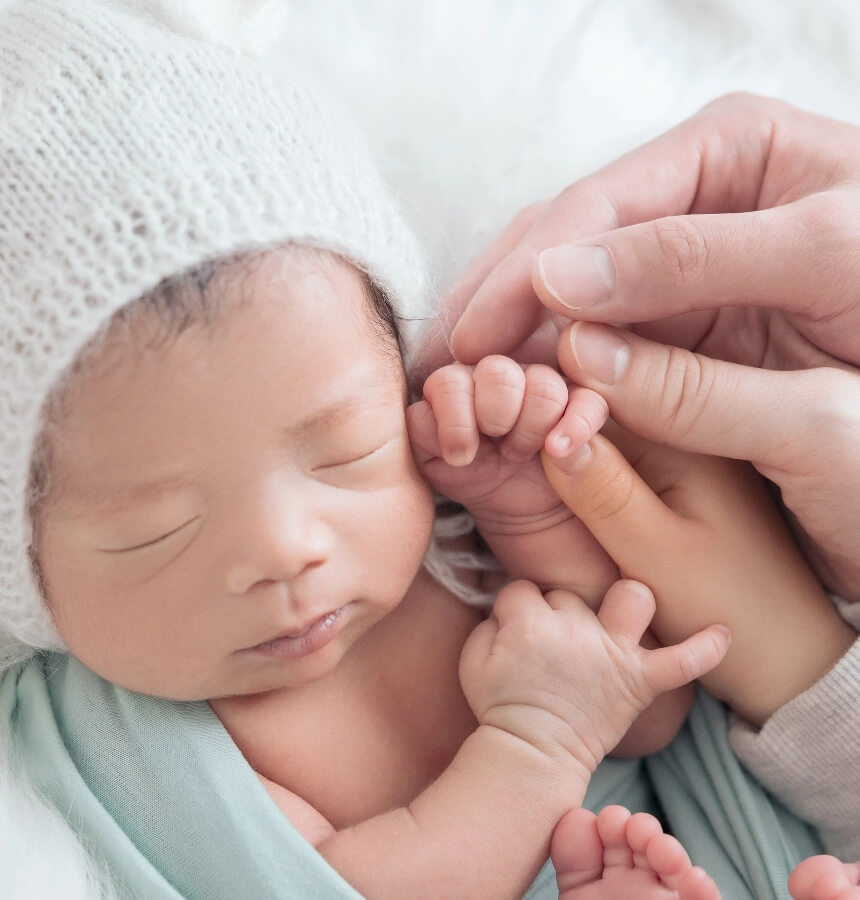 子供の手を家族でつないでる姿